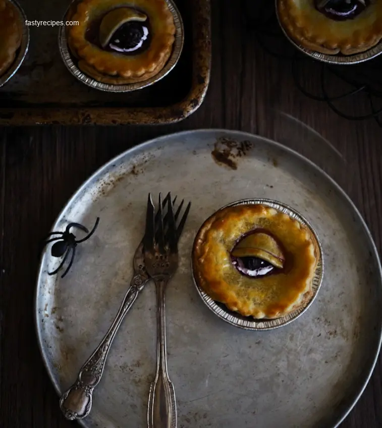 A sliced creepy eye pie on a black plate