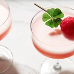 A frothy, perfectly mixed Clover Club drink served in clear stemware.