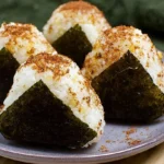 Several delicious chicken rice balls arranged on a platter, ready to be served.