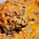 Golden-brown cheesy hamburger rice casserole in a ceramic dish