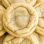 Several freshly baked chewy sugar cookies, perfectly round.