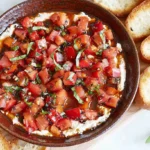 Close-up of a colorful bruschetta dip, featuring diced tomatoes and basil