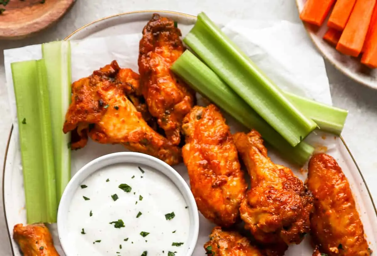 Buffalo Wings: 6 Must-Try Marinade Ideas 2 A plate piled high with crispy, saucy buffalo wings, ready to be eaten.